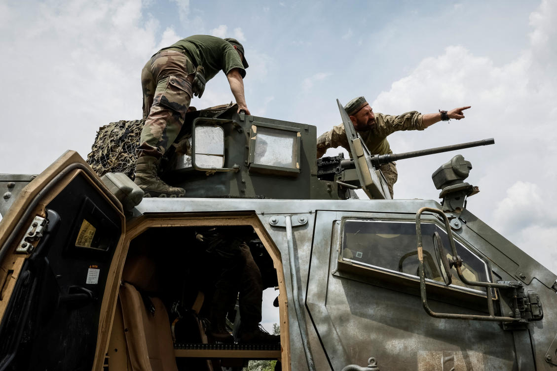Ukrainian service members of the 33rd Separate Mechanized Brigade teach brother-in-arms to fire a M2 Browning machine gun atop of a Mine Resistant Ambush Protected vehicle Oshkosh M-ATV during a military drill near a frontline in Donetsk on Jun. 12, 2024. (Reuters)