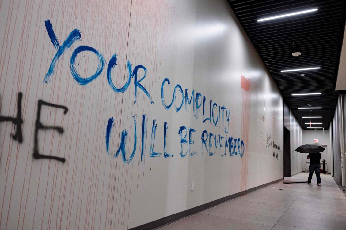 A pro-Palestinian protester walks past a graffiti reading ‘Your Complicity Will Be Remembered’ in a hallway of the California State University Los Angeles (CSULA) Student Services Building in Los Angeles on Jun. 12, 2024. (AFP)