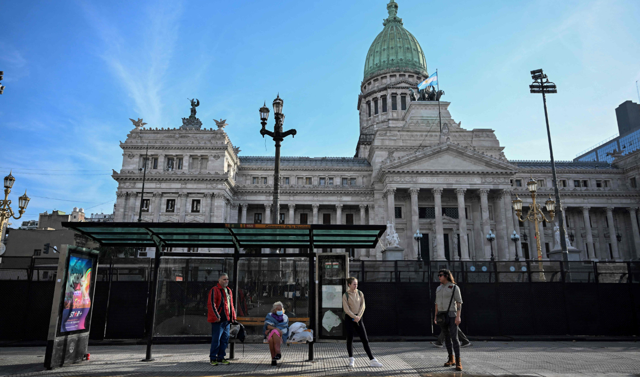 People wait for the bus at a bus station in front of the National Congress in Buenos Aires on June 13, 2024. (AFP)