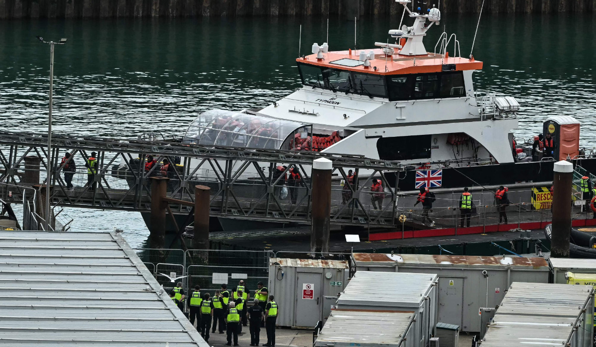 Migrants, including children, picked up at sea attempting to cross the English Channel from France disembark from Border Force vessel "BF Typhons" after arriving at the marina in Dover, southeast England, on June 12, 2024. (AFP)