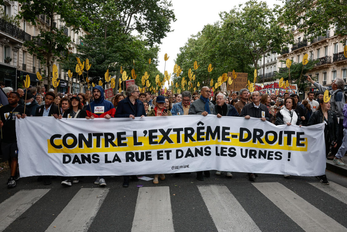 People hold a banner that reads “against the far right, on the street and at the ballot box,” during a demonstration against the French far-right National Rally (Rassemblement National — RN) party, ahead of early legislative elections in Paris on Jun. 15, 2024. (Reuters)