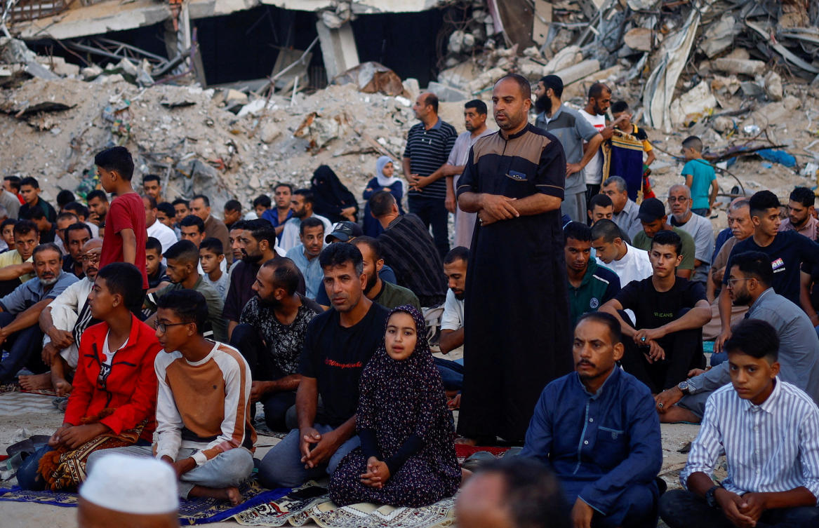 Palestinians hold Eid Al-Adha prayers by the ruins of Al-Al Rahma mosque destroyed by Israeli air strikes in Khan Younis, southern Gaza Strip on June 16, 2024. Hamas said they are ready for a comprehensive deal for Gaza peace. (Reuters)