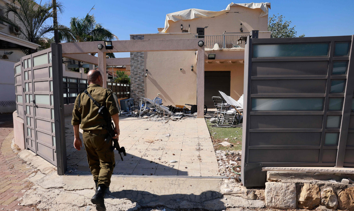 An Israeli soldier checks a house that was hit by a Hezbollah rocket in Kiryat Shmona in northern Israel near the Lebanon border, on June 16, 2024, amid ongoing cross-border clashes between Israeli troops and Hezbollah fighters. (AFP)