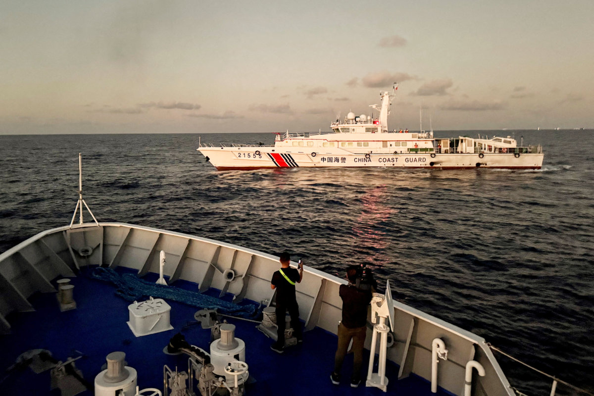 In this photo taken on March 5, 2024, members of the media take footage of a Chinese Coast Guard vessel blocking a Philippine Coast Guard vessel on its way to a resupply mission at Second Thomas Shoal in the South China Sea. (REUTERS/File)