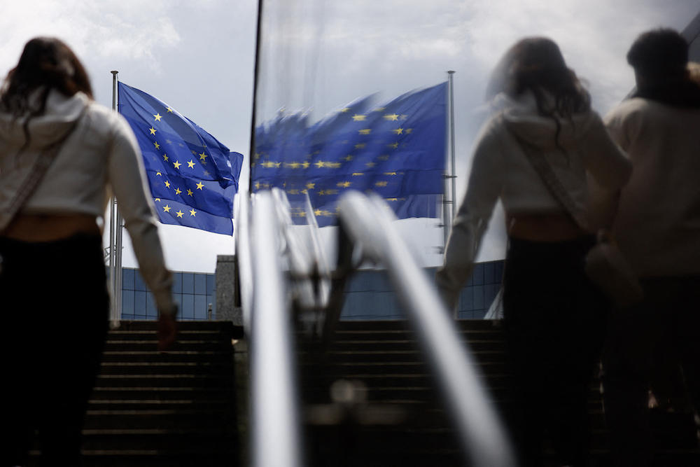 Above, people walk past EU flags 4outside the European Commission headquarters in Brussels on May 23, 2024. Leaders will be meeting on Monday to discuss the bloc’s top jobs. (AFP)