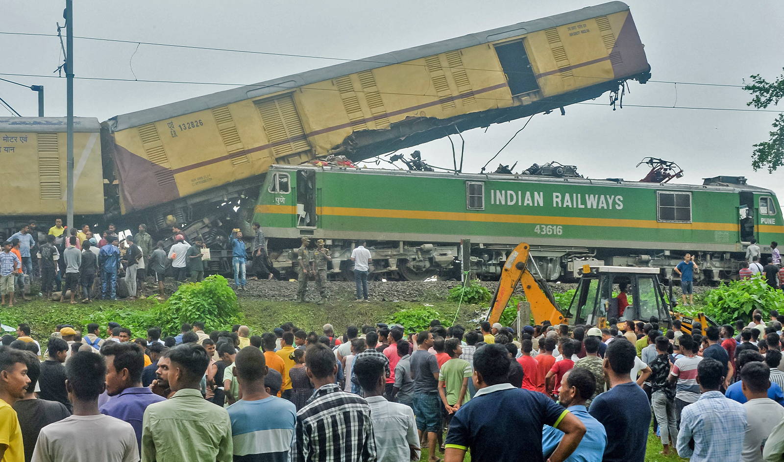 People gather near the site of a collision between an passenger and a goods train in Nirmaljote, near Rangapani station in India's West Bengal state on June 17, 2024. (AFP)
