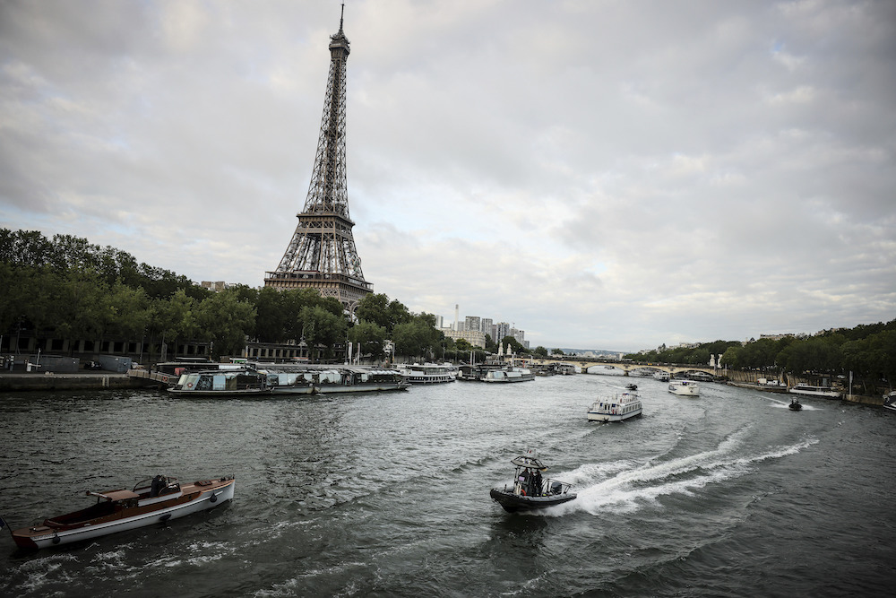Barges cruise on the Seine river during a rehearsal for the Paris 2024 Olympic Games opening ceremony Monday in Paris. The river will host the Olympic Games opening ceremony on July 26 with boats for each national delegation. (AP)