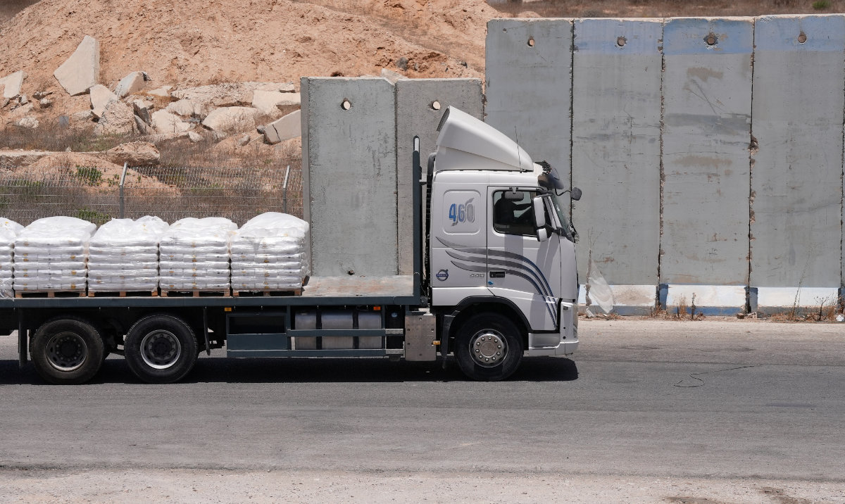 A truck carrying aid for delivery into Gaza drives through the Kerem Shalom crossing in southern Israel, June 17, 2024. (Reuters)
