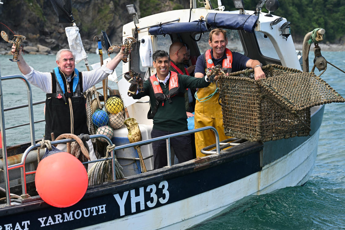 Above, British Prime Minister Rishi Sunak, center, and West Devon MP Geoffrey Cox ride on a boat in the harbor as they collect lobster pots in Clovelly, Britain on June 18, 2024. (Reuters)