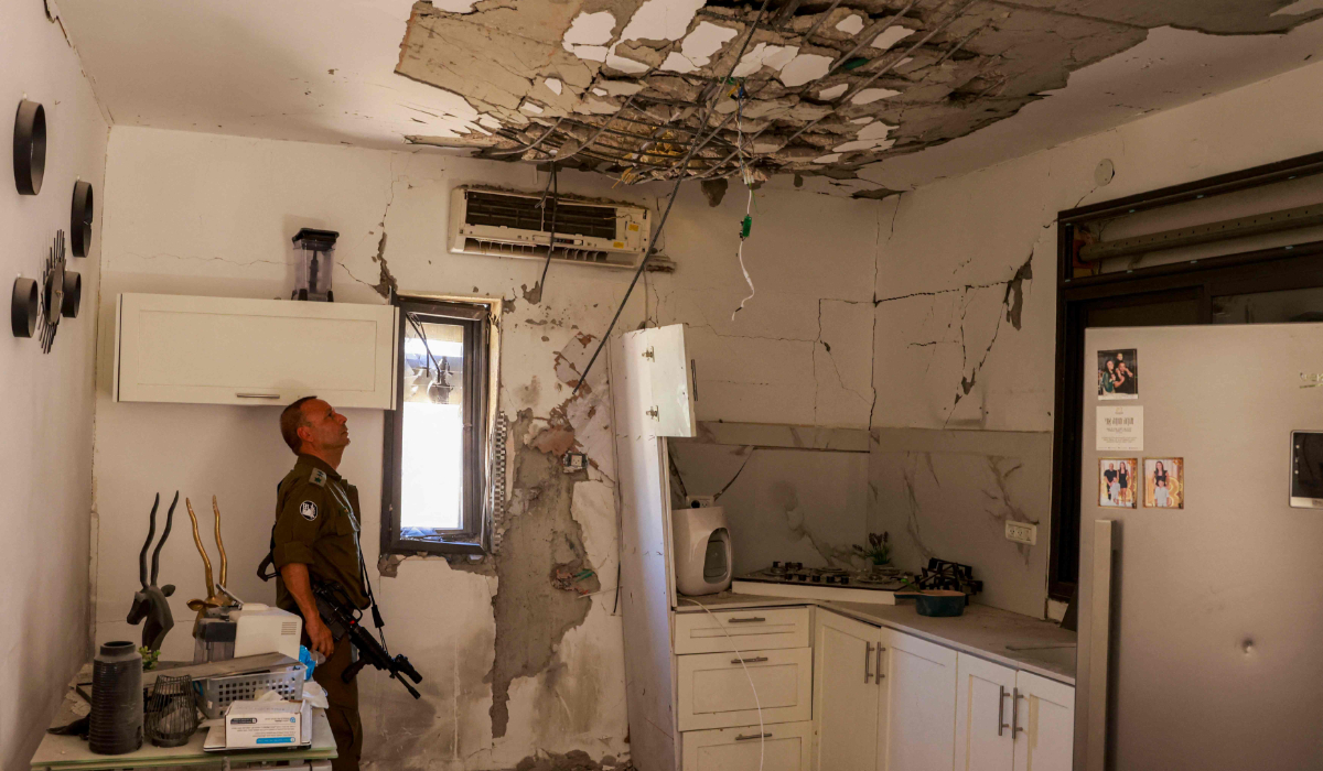 An Israeli soldier checks a house that was hit by a Hezbollah rocket in Kiryat Shmona in northern Israel near the Lebanon border, on June 16, 2024, amid ongoing cross-border clashes between Israeli troops and Hezbollah fighters. (AFP)