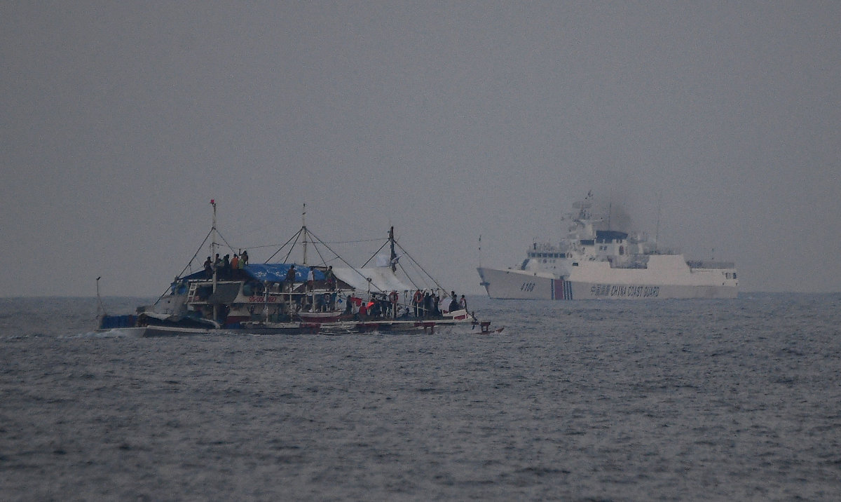 A China Coast Guard ship (R) sailing past a Philippine fishing boat with volunteers from the civilian-led mission Atin Ito (This Is Ours) Coalition on board, in the disputed South China Sea on May 15, 2024. (AFP)
