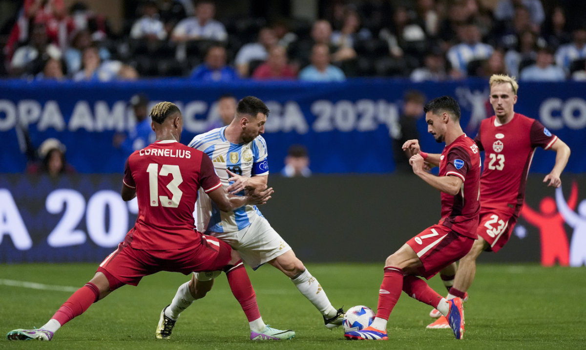 Argentina's Lionel Messi, center, and Canada's Derek Cornelius, 13, battle for the ball during a Copa America Group A soccer match in Atlanta, Thursday, June 20, 2024. (AP)