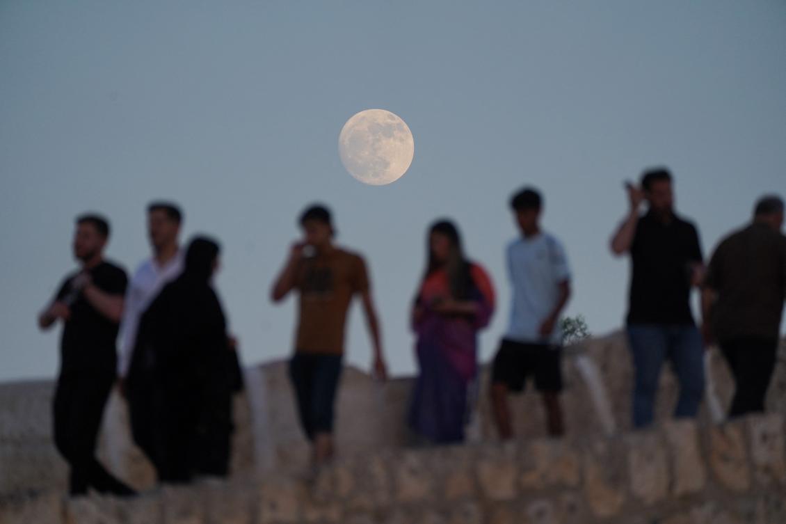 The full moon rises behind the Abbasid Bridge or know in Kurdish as Dalal Bridgein Kurdish, in the city of Zakho in Iraq’s northern autonomous Kurdistan region close to the Turkish border on June 20, 2024. (AFP)