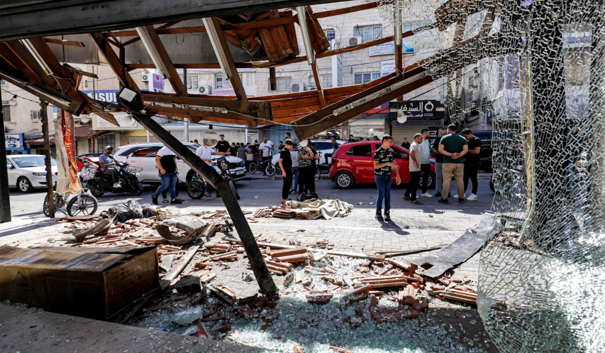 People gather at the site where two Palestinians were killed during an Israeli operation in Qalqilya in the occupied West Bank on June 21, 2024. (AFP)