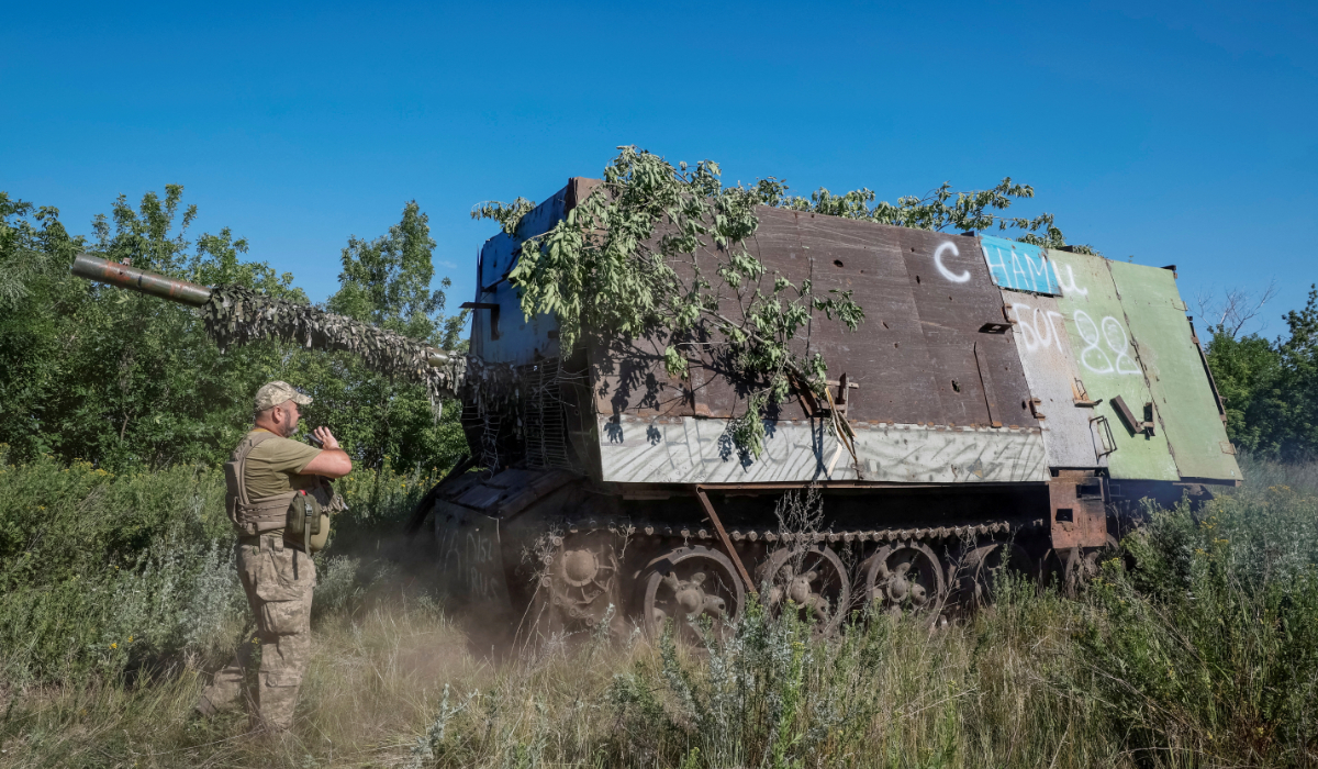 A Ukrainian serviceman of the 22nd Separate Mechanised Brigade stands next to a Russian T-62 Soviet main battle tank crafted with anti-drone protection that was recently captured by his unit, amid Russia's attack on Ukraine, at an undisclosed location in Donetsk region, Ukraine, June 19, 2024. (REUTERS)