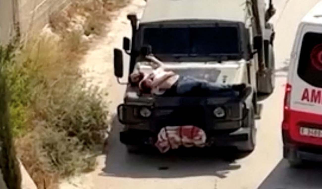 Israeli army straps Palestinian on military jeep during raid in Jenin, in this screengrab from a video, in the Israeli-occupied West Bank, June 22, 2024. (Reuters)