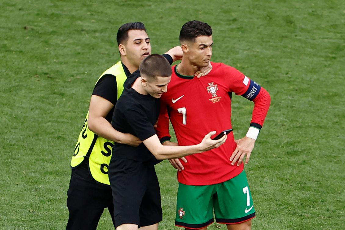 A pitch invader takes a selfie photograph with Portugal’s forward Cristiano Ronaldo during the UEFA Euro 2024 Group F football match between Turkiye and Portugal in Dortmund on June 22, 2024. (AFP)