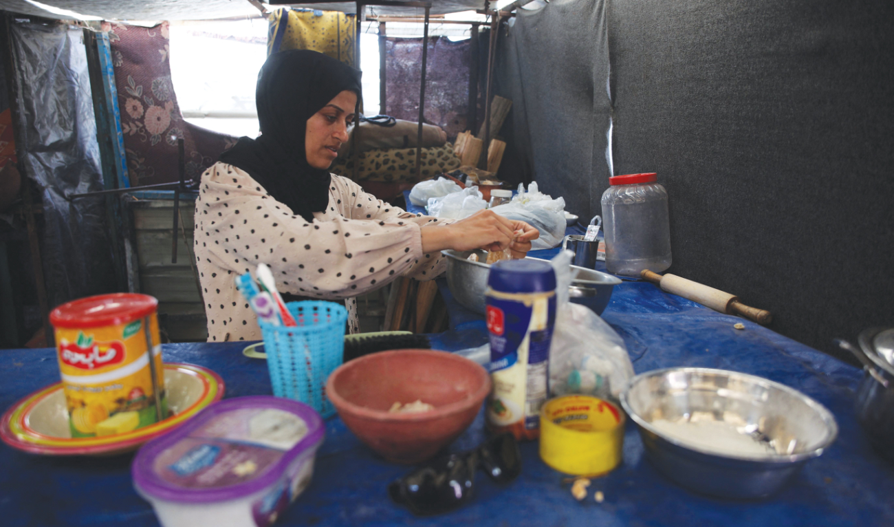 A Palestinian woman works in a makeshift kitchen in the Jabalia refugee camp. (File/AFP)