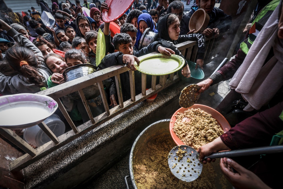 File photo Displaced Palestinian children gather to receive food at a government school in Rafah in the southern Gaza Strip on February 19, 2024, amid the ongoing battles between Israel and the militant group Hamas.(AFP)