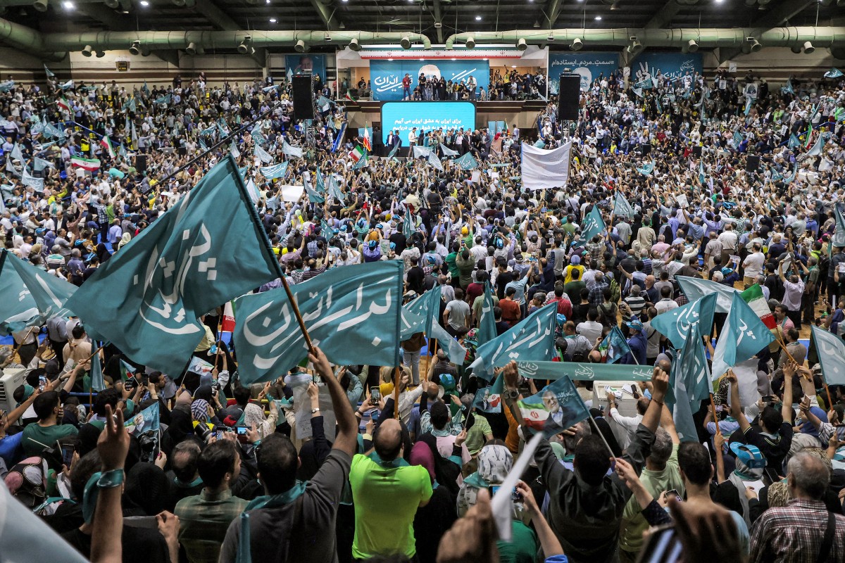 Supporters cheer during a campaign rally for reformist candidate Massoud Pezeshkian at Afrasiabi Stadium in Tehran on June 23, 2024 ahead of the upcoming Iranian presidential election. (AFP)