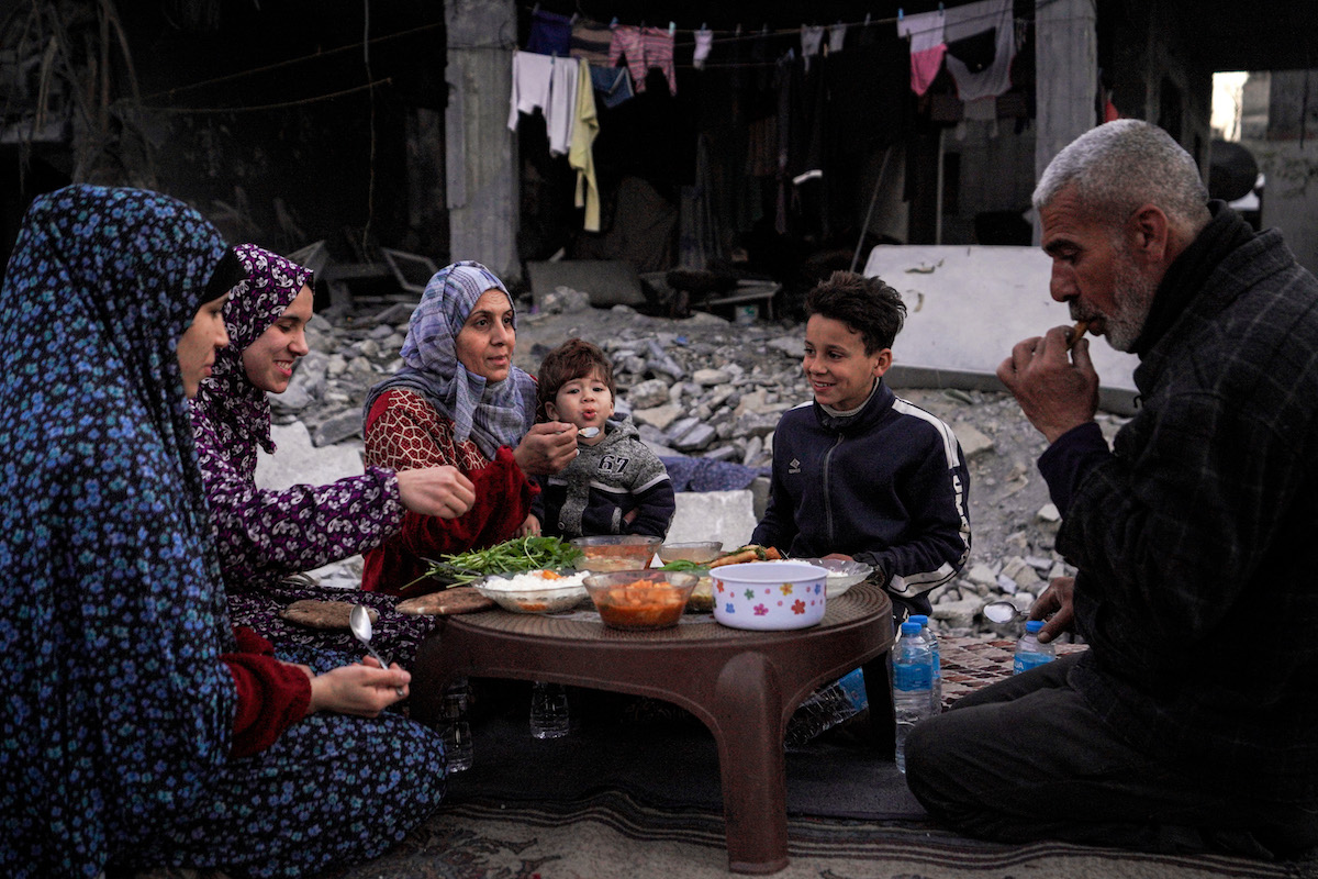 The Palestinian Al-Naji family eats an iftar meal, the breaking of fast, amidst the ruins of their family house,