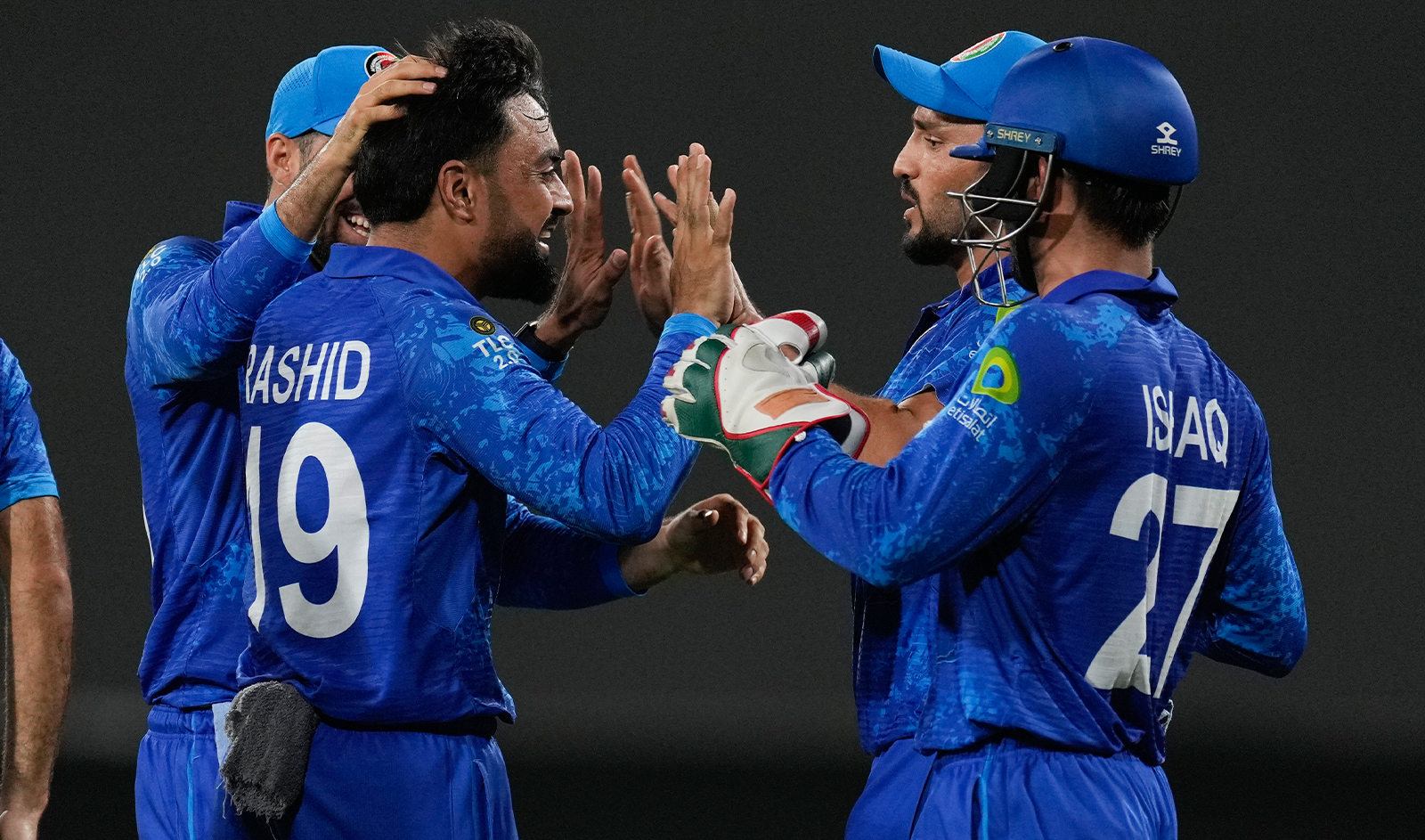 Afghanistan's captain Rashid Khan is congratulated by teammates after dismissing Bangladesh's Soumya Sarkar during the men's T20 World Cup cricket match between Afghanistan and Bangladesh at Arnos Vale Ground, Kingstown, Saint Vincent and the Grenadines, on June 24, 2024. (AP)