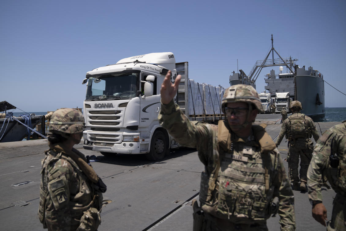 A US Army soldier gestures as trucks loaded with humanitarian aid arrive at the US-built floating pier Trident before reaching the beach on the coast of the Gaza Strip, Tuesday, June 25, 2024. (AP)