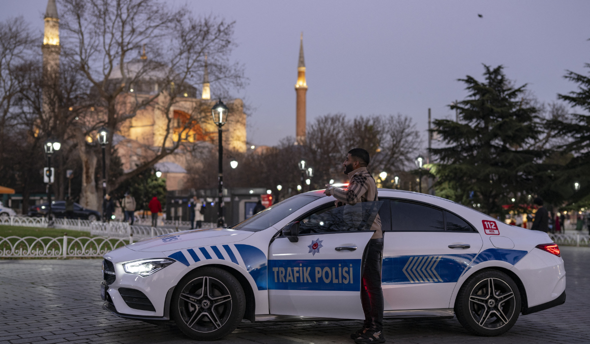 A man poses for a photograph next to a Mercedes converted into a police vehicle, on display at Hagia Sophia Square in Istanbul on December 27, 2023. (AFP file photo)