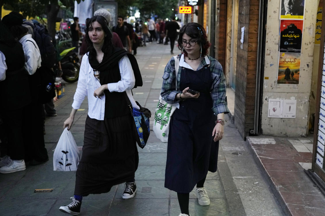 Two Iranian women without wearing their mandatory Islamic headscarf walk in downtown Tehran. (AP)