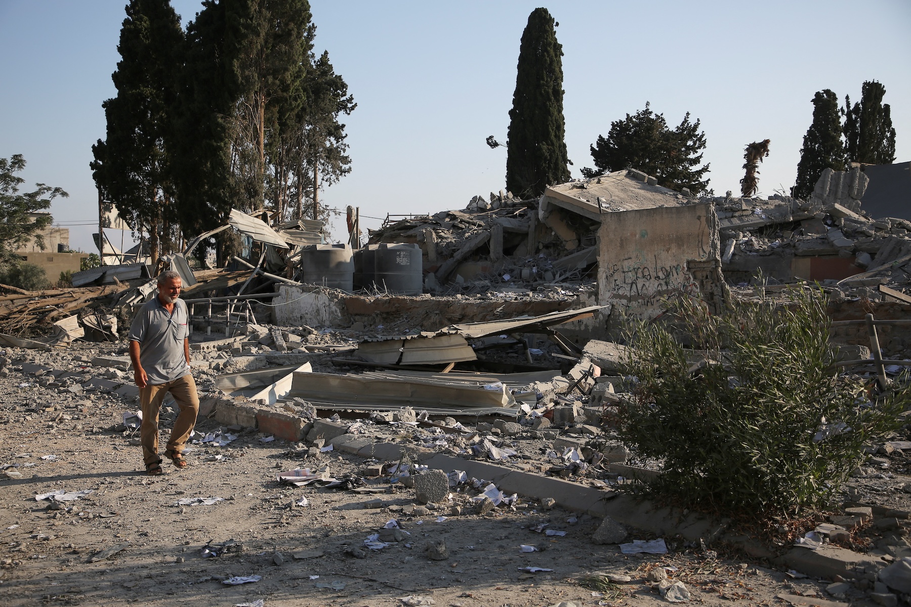 A Palestinian man walks near rubble, following an Israeli strike on a school sheltering displaced people, amid the Israel-Hamas conflict, in Khan Younis, in the southern Gaza Strip, June 27, 2024. (REUTERS)