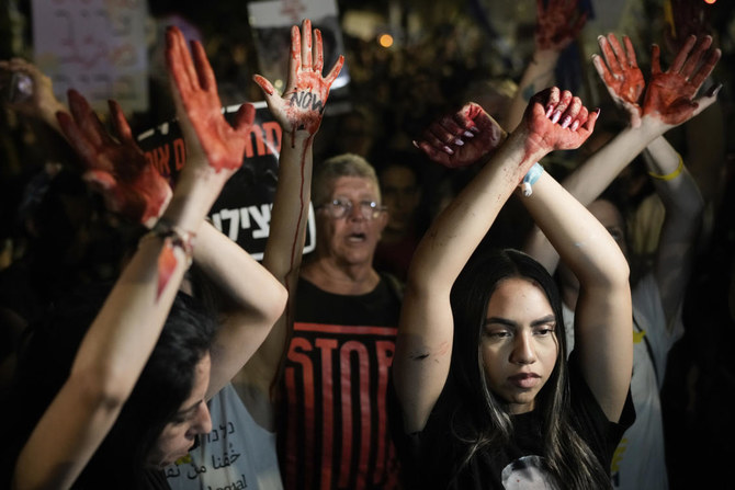 Demonstrators hold up their hands, painted red to symbolize blood during a protest against Israeli Prime Minister Benjamin Netanyahu’s government and call for the release of hostages held in Gaza by Hamas, in Jerusalem, on Jun. 27, 2024. (AP)