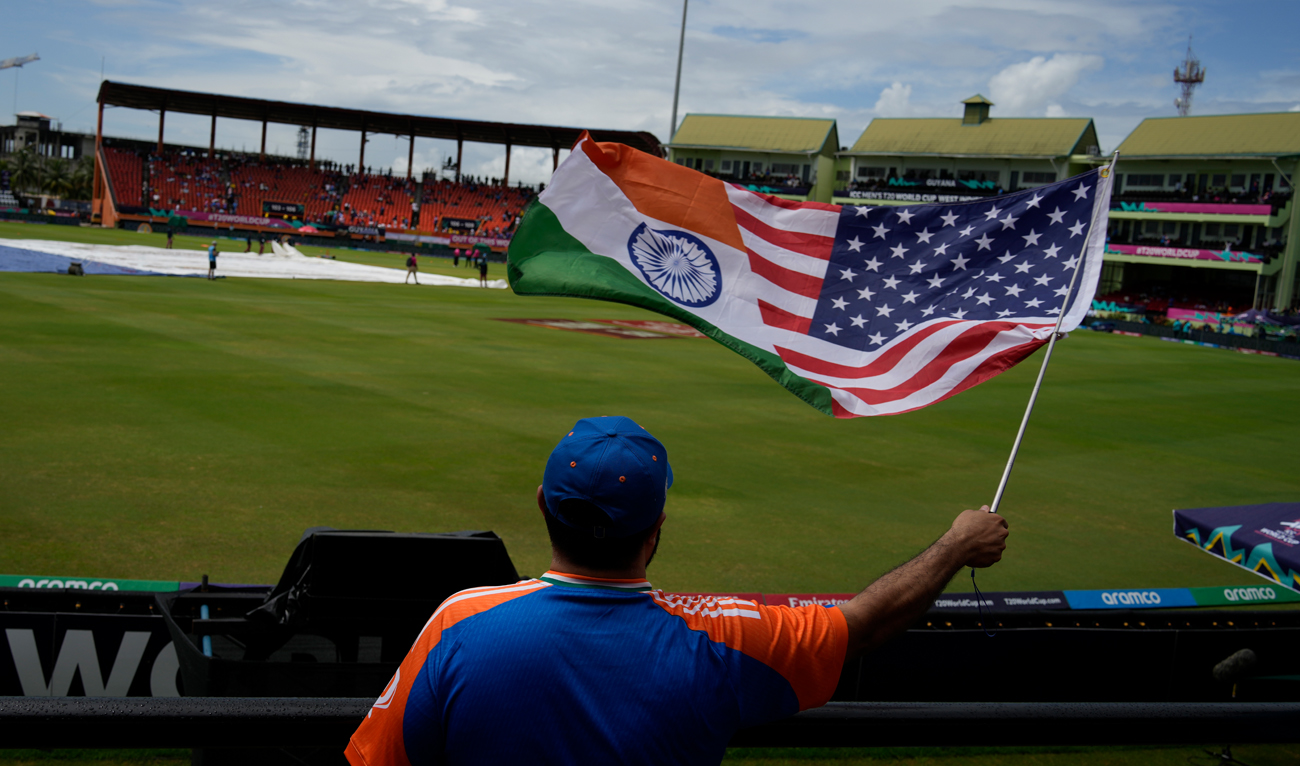 A fan waves a flag as he waits in the stands after wet outfield delayed the start of the ICC Men’s T20 World Cup second semifinal cricket match between England and India at the Guyana National Stadium in Providence, Guyana, Thursday, June 27, 2024. (AP)