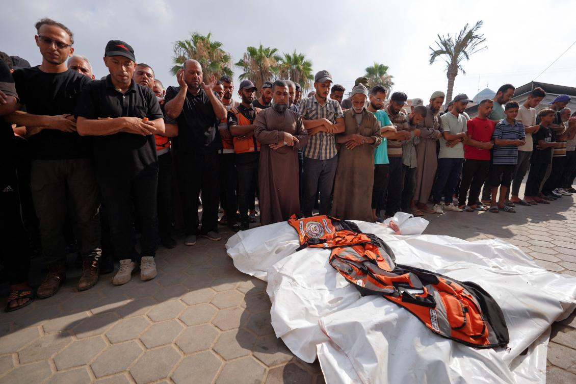 Above, mourners pray over the bodies of four civil defense volunteers killed during the Israeli bombardment of the Nuseirat refugee camp on June 28, 2024. (AFP)