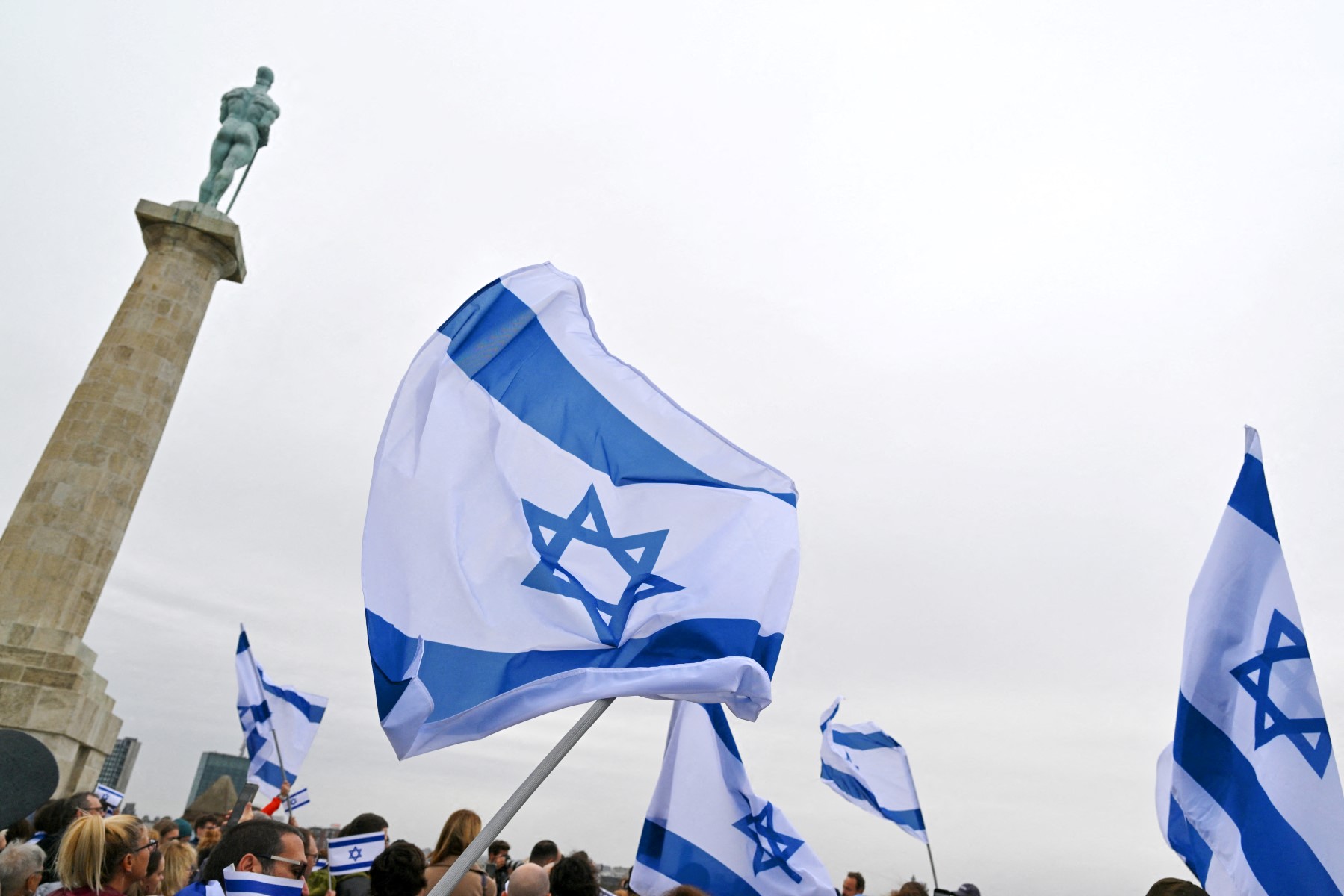 Protestors wave Israeli flags during the "Walk for peace in Israel" in support of the people of Israel, in Belgrade on October 15, 2023, following the October 7 Hamas attacks in Israel. (AFP)