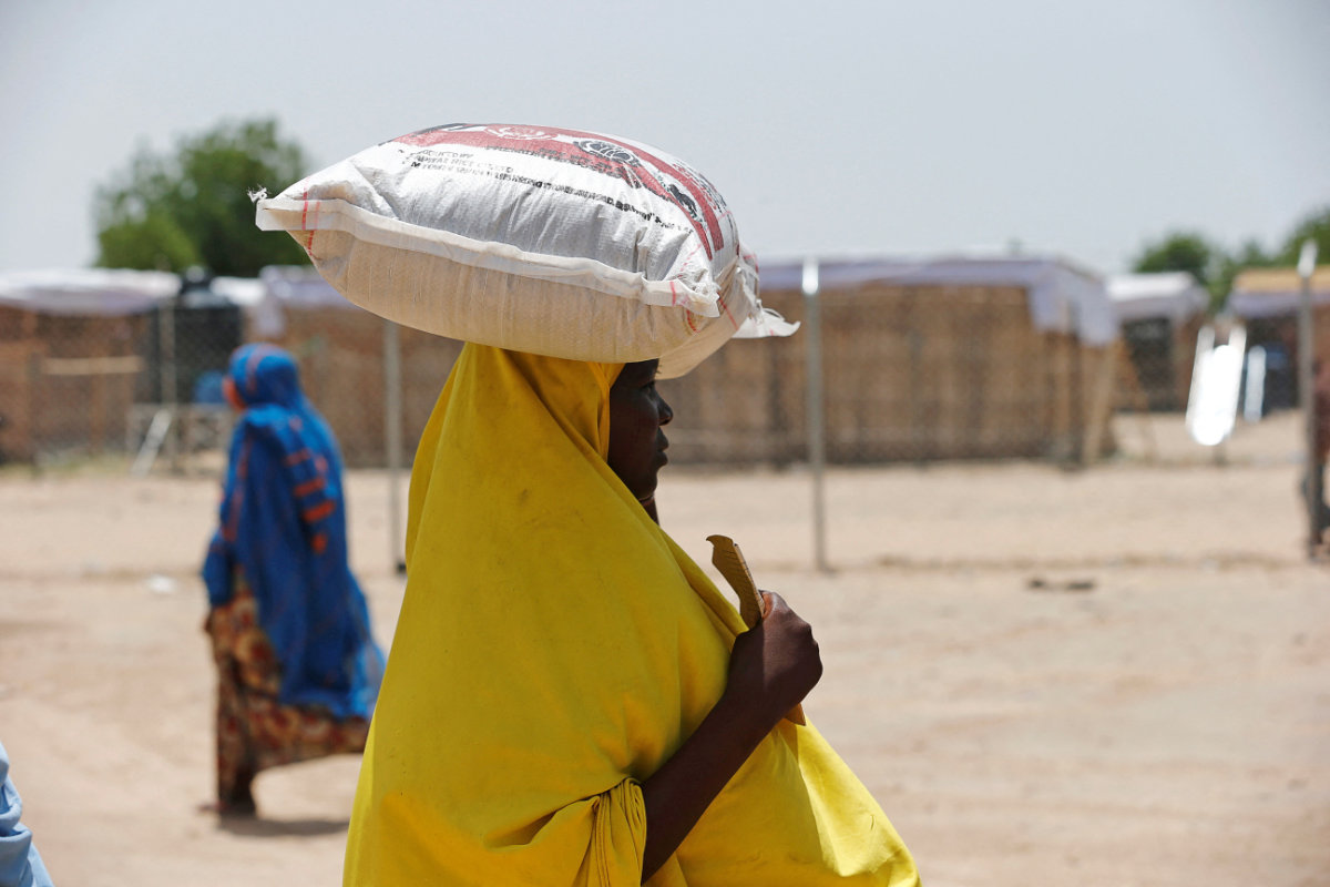 A woman carries a bag of rice during a food rationing at an internally displaced persons camp on the outskirts of Maiduguri, northeast Nigeria, on June 6, 2017. (REUTERS)