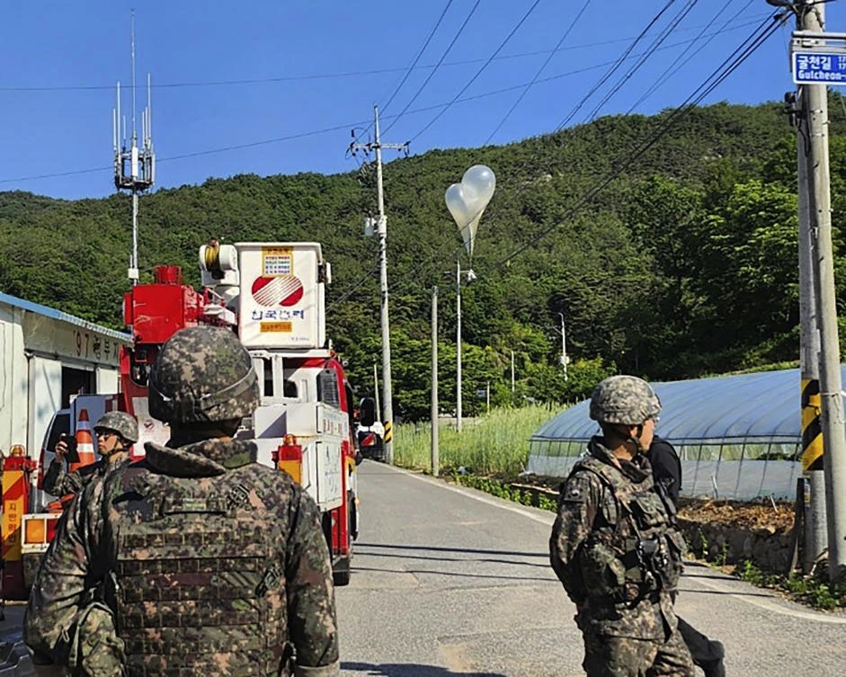 In this photo provided by Jeonbuk Fire Headquarters, balloons with trash presumably sent by North Korea, hang on electric wires as South Korean army soldiers stand guard in Muju, South Korea, on May 29, 2024. (AP)