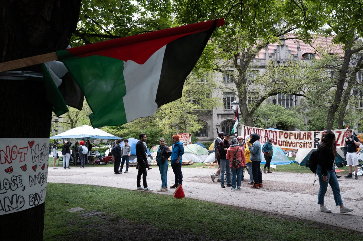 In this photo taken on on May 03, 2024, a Palestinian flag flies near a group of activists at an encampment protesting the war in Gaza on the campus of the University of Chicago in , Illinois. (Getty Images/AFP)