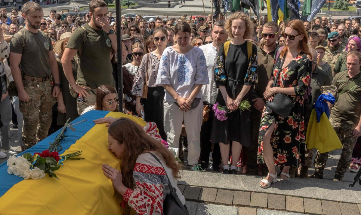 Mourners cry over the coffin of Iryna "Cheka" Tsybukh, a combat medic of the Hospitallers volunteer battalion, who was killed in action in the Kharkiv region, during her funeral ceremony at Saint Michael's Golden-Domed Monastery in Kyiv, on June 2, 2024, amid the Russian invasion of Ukraine. (AFP)
