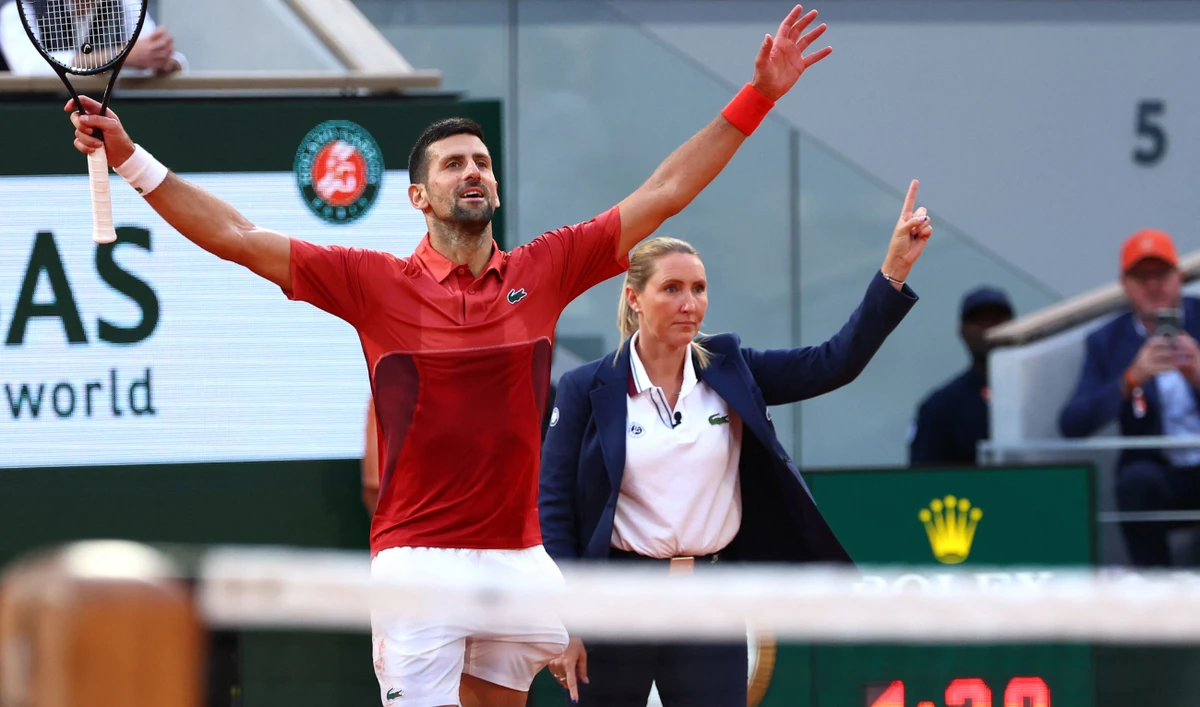 Serbia's Novak Djokovic (L) celebrates next to the umpire and a timer clock reading 4 hours and 39 minutes after winning against Argentina's Francisco Cerundolo in their round of 16 at the French Open tennis tournament at Roland Garros Complex in Paris on June 3, 2024. (AFP)