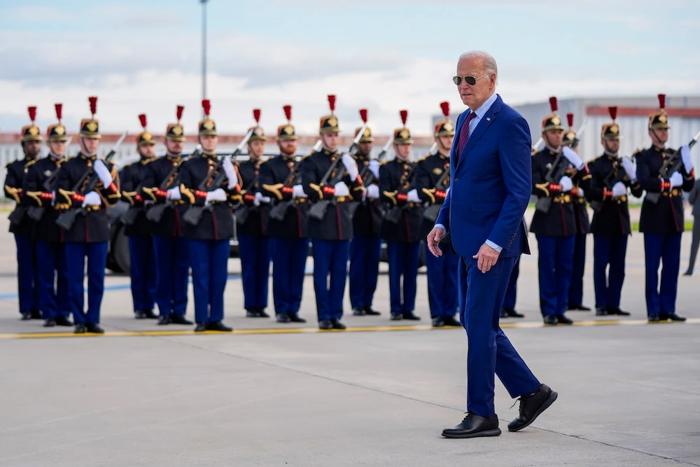 US president Joe Biden walks next to a French honor guard after arriving at Orly airport, south of Paris on June 5, 2024. Biden is in France to mark the 80th anniversary of D-Day. (AP)