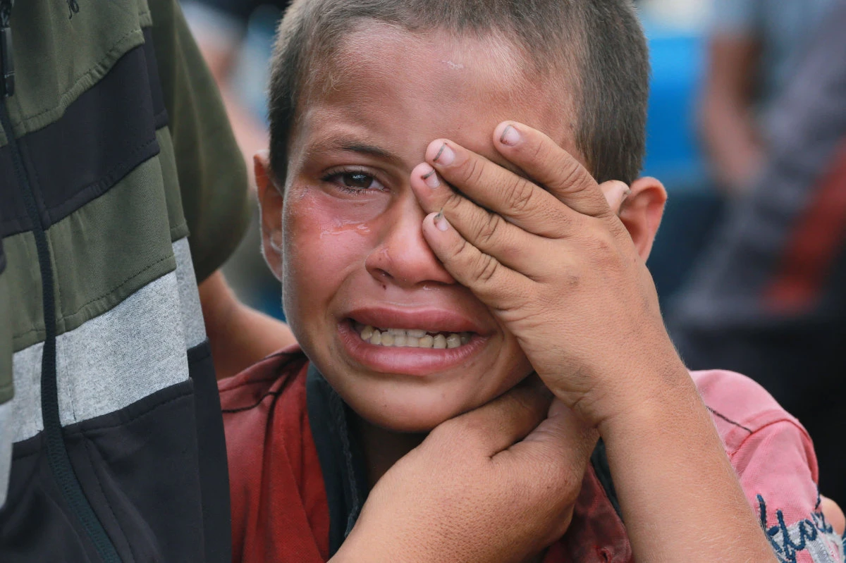 A displaced Palestinian boy weeps during a funeral rite on June 3, 2024, for his father, killed by an Israeli airstrike the previous night in the central Gaza Strip. (AFP)
