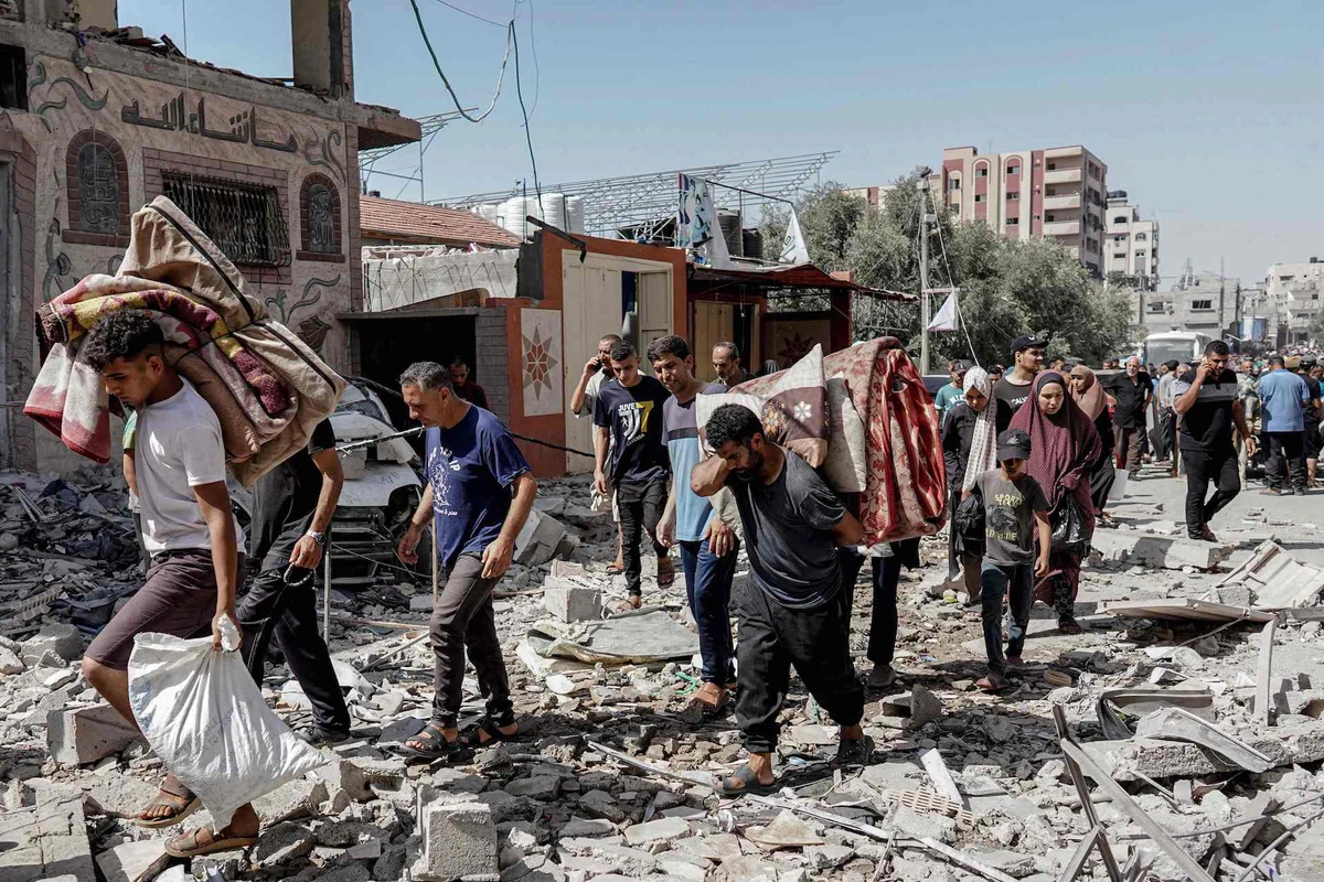 Palestinians evacuate with their belongings following an operation by the Israeli Special Forces in the Nuseirat camp, in the central Gaza Strip on June 8, 2024. (AFP)