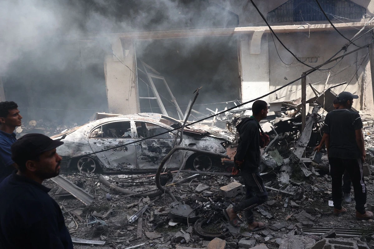 Palestinian men look at the destruction following an operations by the Israeli Special Forces in the Nuseirat camp, in the central Gaza Strip on June 8, 2024. (AFP)