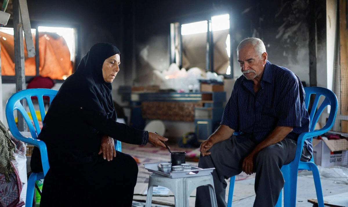 Palestinian couple Mahmoud and Fatima Jarghoun sit inside their damaged home while talking about not being able to make the Hajj pilgrimage due to the closure of the Rafah border crossing, amid the Israel-Hamas conflict, in Khan Younis, in the southern Gaza Strip, June 3, 2024. (Reuters)