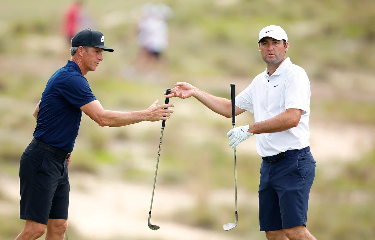 Scottie Scheffler of the US hands a club to his caddie, Ted Scott, on the fifth hole during a practice round prior to the US Open at Pinehurst Resort on June 12, 2024 in Pinehurst, North Carolina. (AFP)