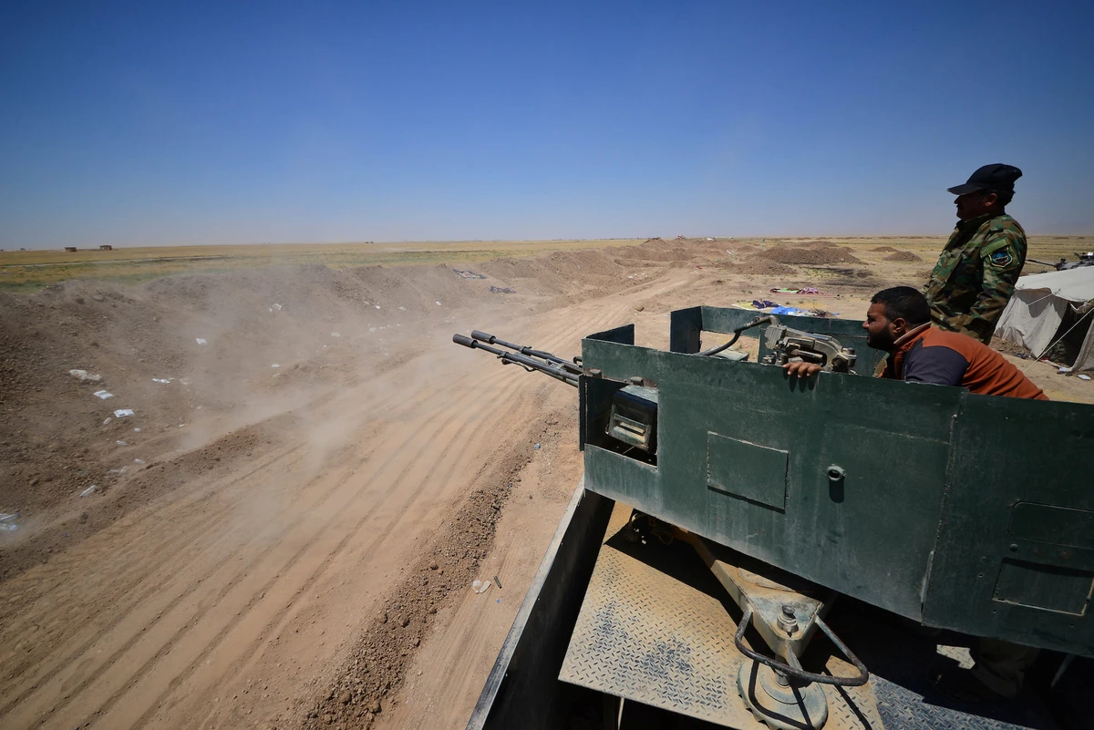 Popular Mobilization Forces (PMF) ride in a military vehicle on the Iraqi border with Syria, west of Mosul, Iraq June 12, 2017. Picture taken June 12, 2017. (Reuters)