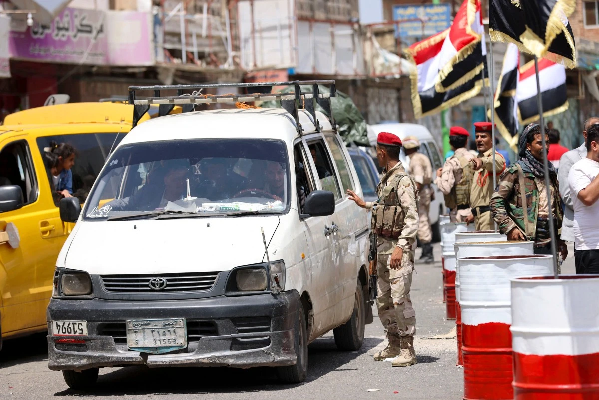 The ID of a driver is checked as people celebrate the reopening of the road from the city of Taiz, in the southwest of the country, to the Huthi-controlled capital Sanaa, after barriers were removed, on June 13, 2024. (File/AFP)