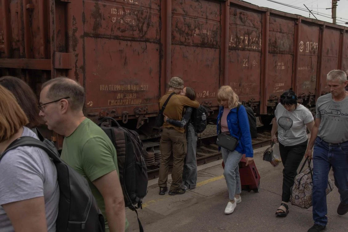 A Ukrainian serviceman kisses his partner after she arrived by train from Kyiv, on the platform of a railway station in Kramatorsk, Donetsk region, on Jun. 15, 2024. (AFP)