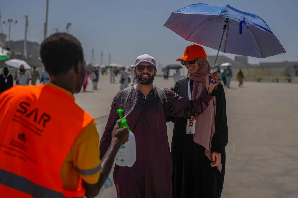 A pilgrim is sprayed with cold water after he cast stones at a pillar in the symbolic stoning of the devil, the last rite of the Hajj pilgrimage in Mina, near Makkah, Saudi Arabia, June 18, 2024. (AP Photo)