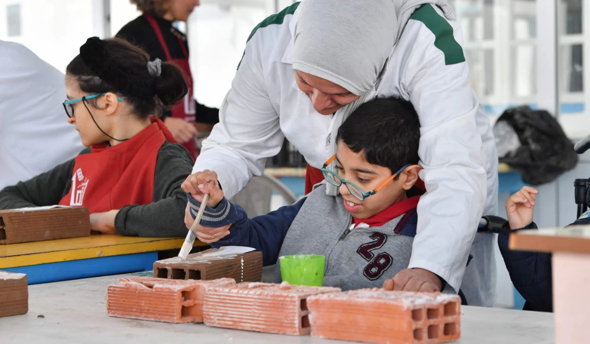 A group of young people with disabilities participate in the creation of a collaborative work of art at an institute that offers educational, artistic and social programs in La Marsa, a suburb of Tunis, on February 22, 2024. (AFP)